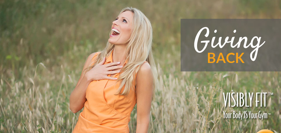 Photo of joyful Wendie Pett and a "Giving Back" sign