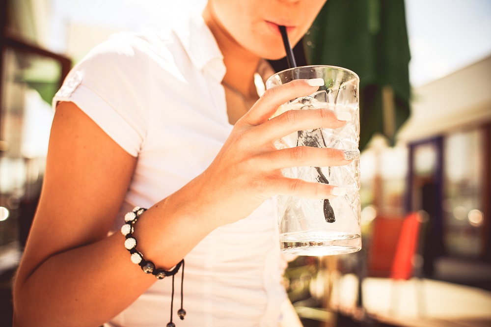 Woman drinking a glass of water to represent how to get Visibly Fit™ drinks with Wendie Pett, ND.