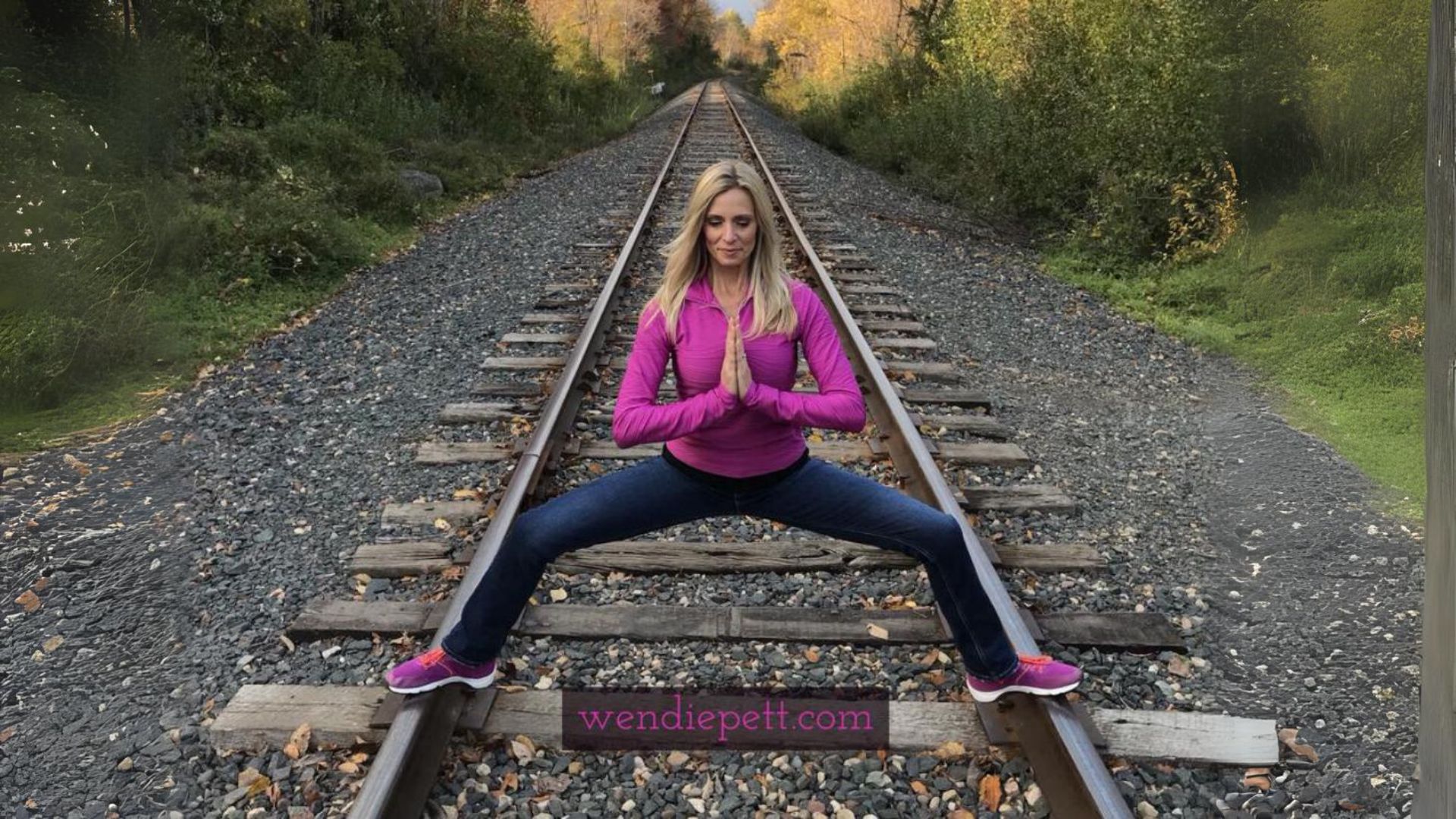 Wendie Pett squatting on train tracks praying to help get your health on track. Grab the FREE Visibly Fit™ in 7 days workout and meal plan with bonus healthy travel tips at WendiePett.com/visibly-fit-in-7-days/