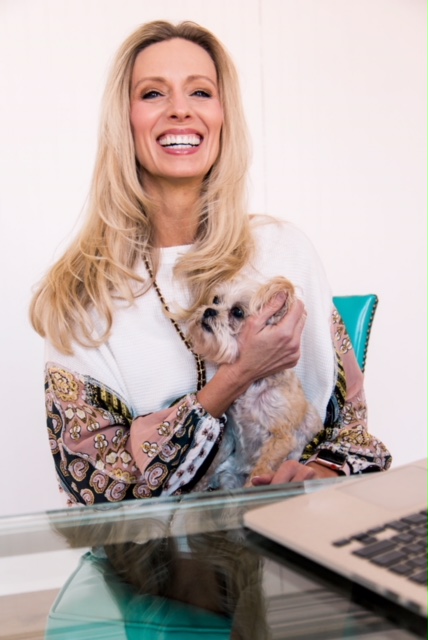 Wendie Pett ND of Get Visibly Fit smiling with an adorable dog at her desk.